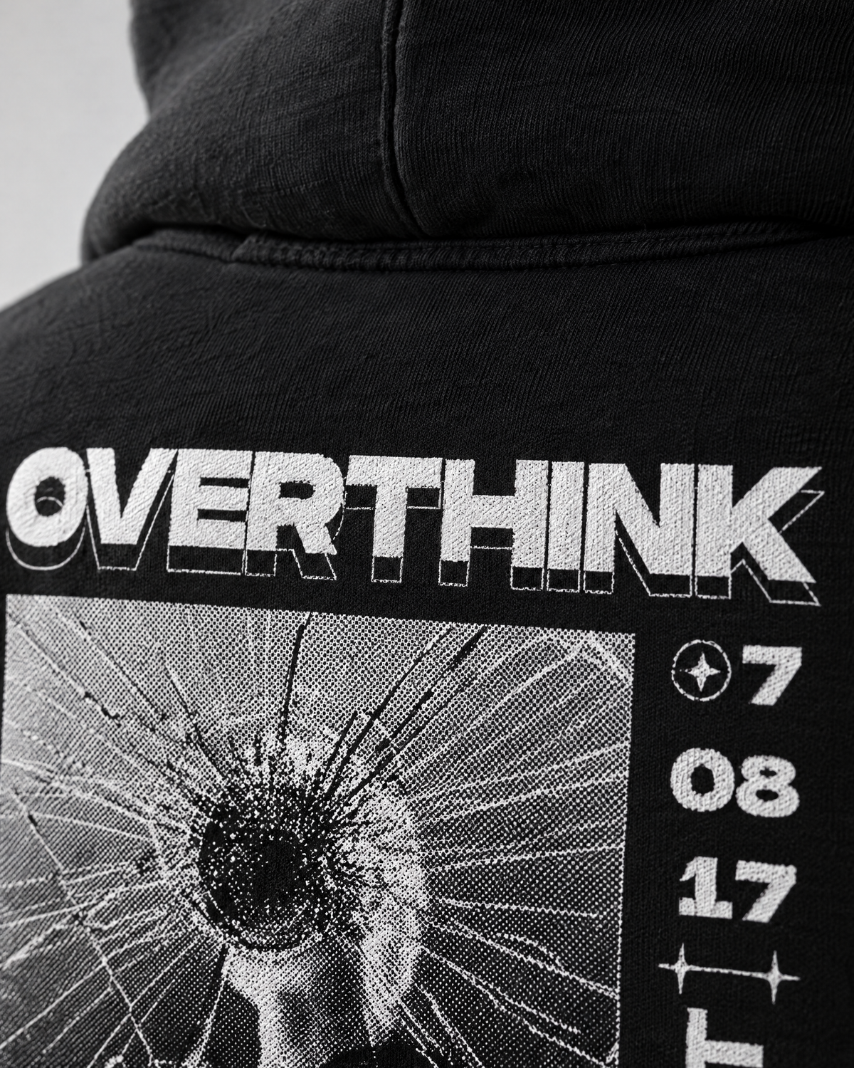 Dettaglio della stampa Overthink sul tessuto nero della felpa